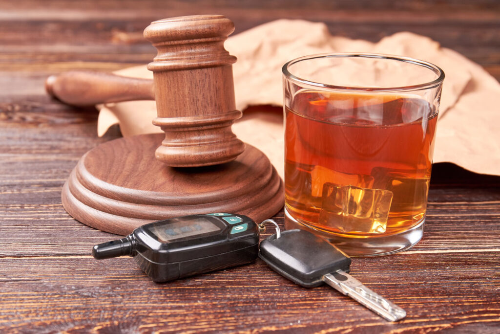 A table with a glass of drinks and a set of keys, emphasizing the importance of a DUI assessment to prevent driving under the influence