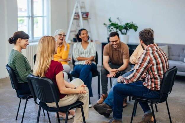 A group of people participating in an Intensive Outpatient Treatment (IOP) session, with a therapist leading the discussion in a supportive environment